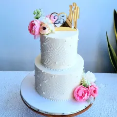 A classic white, two-tiered anniversary cake. I teach how to create the delicate lace pattern using a stencil and royal icing, and how to arrange flowers for an elegant look.
