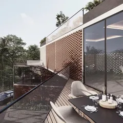 The restaurant terrace at the Kolgaon clubhouse provides a beautiful setting for outdoor dining. The space is enclosed by glass and protected by a perforated brick screen, offering both views and privacy.