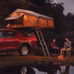 A lifestyle shot for the Toyota Hilux campaign, styled for a camping scenario. The comfortable, layered outdoor wear on the models helps create an authentic scene of enjoying nature with the help of a capable vehicle.
