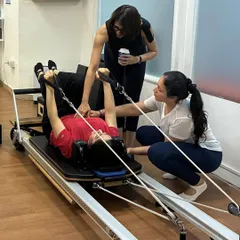 Two instructors provide detailed, hands-on guidance to a student during an instructor training session, showcasing our commitment to precise movement.