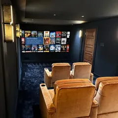 This is the same subtle and elegant home cinema room, but this angle shows the large screen displaying the OTT media library. You have endless entertainment options right at your fingertips, from blockbuster movies to your favorite TV series.
