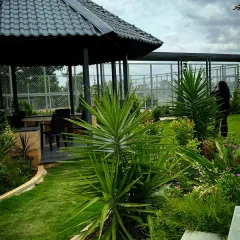 A shaded gazebo at Serene Exotica provides a quiet, sheltered spot for residents to sit and enjoy views of the surrounding gardens and sports courts.