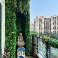 This apartment balcony was transformed into a tranquil sanctuary with a custom vertical garden. The design incorporates a niche for a Buddha statue, creating a peaceful meditation corner with a beautiful city view.