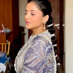 A detailed look at this chic and modern bubble ponytail. It's a fun and stylish alternative to a traditional updo, especially when paired with a glamorous outfit.