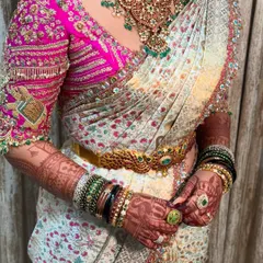 A stunning bridal look where the saree drape is as important as the hair and makeup. The pleats are neat, the pallu is perfectly placed, and the vaddanam completes the look.