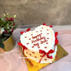 I love making these vintage-style heart cakes. This one features delicate buttercream piping, tiny red hearts, and elegant red ribbons, creating a timeless look for a special birthday. It’s a beautiful way to express your love with a classic design.