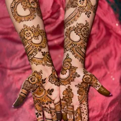 This designer engagement mehendi uses negative space and bold, jewelry-like patterns to create a unique and modern look.
