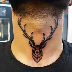 A strong and noble deer tattoo on the back of the neck. The bold lines and shading give this piece a powerful presence, symbolizing peace and good luck.
