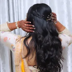 A view of the elegant half-up, half-down hairstyle with soft waves, perfect for an engagement ceremony.