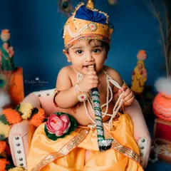 Here, our little Krishna curiously nibbles on his flute. It's these unscripted, natural moments that make for the most memorable baby portraits.