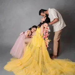 A bright and joyful family maternity photo. The mom's stunning yellow gown and the loving interactions between dad, daughter, and the bump make this a truly happy picture.