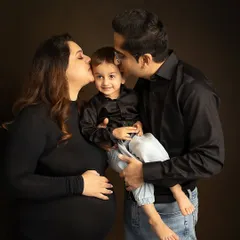 Kisses from mom and dad for the little one in the middle. This pose is all about surrounding your child with love as you all await the new arrival. A beautiful memory from a family maternity shoot in my Pune studio.