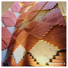 The feature wall at our Green Bean project in Jaipur during construction. This image reveals the intricate process of laying bricks to create a stepped, diamond-like pattern inspired by Rajasthani stepwells.