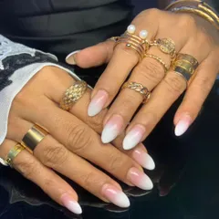 A beautiful example of a classic baby boomer ombre on long, almond-shaped nail extensions, showcasing a seamless blend.