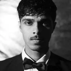 A sharp, classic black and white headshot. The direct lighting and intense expression make this a powerful and essential shot for any male model's portfolio.