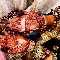 A beautiful candid shot of the rich henna stain, perfectly complementing the bride's ornate wedding outfit and jewelry.