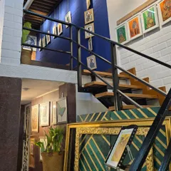 The gallery's mezzanine level, with its distinctive blue wall and staircase, offers a unique perspective and additional space for displaying smaller or themed collections.