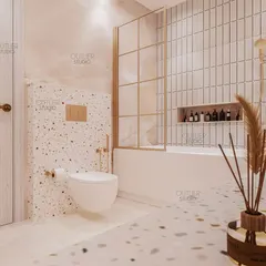 A closer look at the kids' bathroom, showing the use of terrazzo-style tiles and a simple, clean bathtub area with a gold-framed glass partition, blending playfulness with modern design.