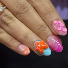 Another view of the holiday beach nails, with a bright orange 3D starfish and other sea-themed accents.