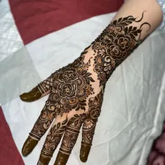 An example of a full-coverage floral design, perfect for a bride's family or for any grand celebration. The pattern features detailed rose motifs and delicate leaf vines covering the hand and arm.