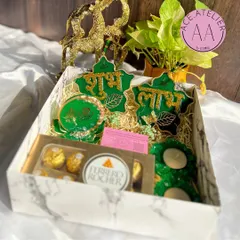 A look inside my green-themed Diwali hamper. This set includes a resin Lakshmi Ganesh standee, matching Shubh Labh hangings, and floral t-light holders, all nestled in a marble-finish gift box.
