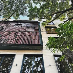A detail of the mixed-use building's facade, highlighting the textured tile cladding that adds a layer of craftsmanship and visual interest.