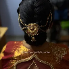 A beautiful and elegant bridal bun for a naming ceremony. This clean, classic updo is adorned with a traditional hair accessory, making it perfect for any formal occasion.