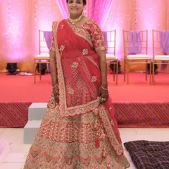 A bride looking gorgeous in a red and peach toned lehenga. The detailed embroidery and flattering silhouette make it a wonderful choice for the wedding day.