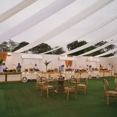 Another perspective of our elegant outdoor setup, showcasing the clean lines of the white food carts against the green lawn and draped ceiling. The layout is designed for easy guest flow.