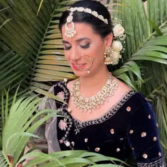 A soft, demure pose from the same shoot, highlighting the flawless makeup and traditional jewelry.