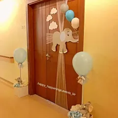 The celebration starts at the door. For our elephant-themed baby welcome, we created this charming door decoration featuring a baby elephant cutout, fluffy clouds, and balloons to greet guests.