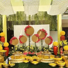 A beautiful setup for a Haldi ceremony, with brass urlis and bowls filled with turmeric and flowers. The backdrop of yellow drapes and unique floral arrangements creates a traditional yet stylish look.