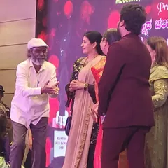 A candid moment on stage during the "ದಶಕದ ಸಂಭ್ರಮ" (Decade's Celebration) event, featuring esteemed guests and artists. I ensure the stage is well-lit and organized for such important interactions.