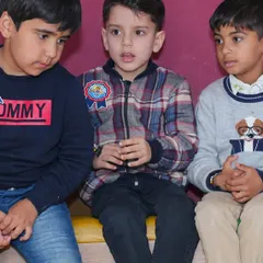 Three boys intently watching the entertainment during a birthday party.