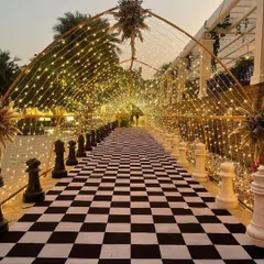 We love creating unique and imaginative entrances that wow your guests from the moment they arrive. This magical walkway features a custom chessboard carpet, giant chess piece props, and a tunnel of warm fairy lights, setting a playful and enchanting tone for the event.