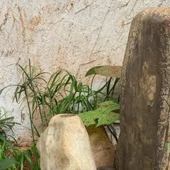 A close-up of a custom stone water fountain, designed to look like a natural rock formation with water bubbling from the top.