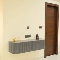 A detailed shot of the floating console table with a fluted design. This custom piece provides storage while maintaining a light, modern feel in the entryway.