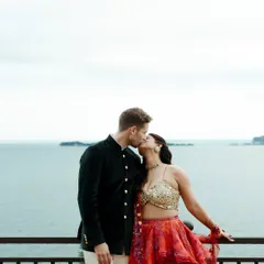 A romantic kiss between the couple, set against the serene backdrop of Lake Garda, Italy. This photograph captures an intimate moment while showcasing the stunning scenery of a destination wedding.