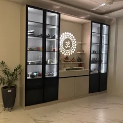 This custom unit seamlessly integrates a modern crockery display with a serene pooja mandir. It features black-framed glass shutters, internal LED lighting for the display sections, and a dedicated, beautifully lit space for worship, solving a common need in Indian homes.