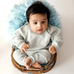 A curious little boy peeking out of a basket. At this age, babies are so alert and engaged with the world, making for adorable and expressive portraits.