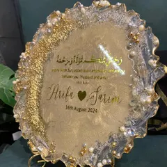 A beautiful resin engagement plaque designed to celebrate a new union. This piece features the couple's names, their special date, and a Quranic verse, all set in a shimmering gold and pearl design with a geode-style edge.