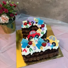 A number "2" monogram cake with a fun car theme. This chocolate cake is perfect for a toddler's birthday, decorated with colorful fondant cars.