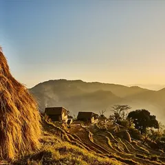 The first light of dawn catches the haystacks and the thatch roofs of our guesthouses in Kumaon. These structures are designed as quiet sanctuaries, offering a place of stillness and disconnection, reached only on foot to preserve the immersive experience of the Himalayas.