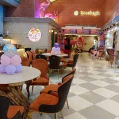 An overview of a restaurant decorated for a party, with balloon centerpieces on each table.