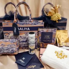 A luxurious personalised gift set created for a 50th wedding anniversary invitation. It includes a custom tote bag, pouch, passport cover, tumbler, and embroidered towel, all in a cohesive, elegant design.