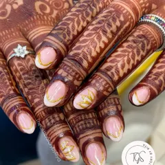 A close-up of this stunning bridal set, where the hand-painted gold leaf design perfectly follows the curves of the henna. It's all about creating a cohesive and elegant look.