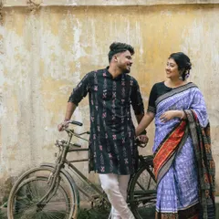 An old-school romance in Sambalpur. The couple, dressed in beautiful Sambalpuri handloom, shares a moment by a classic bicycle against a rustic wall. This heritage-inspired pre-wedding shoot is a nod to timeless love.