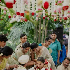 Family members gather to bless the couple under a canopy of flowers. The decor is intentionally kept light and airy to complement the outdoor setting and the morning light.