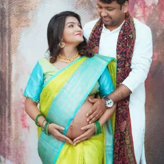 A beautiful couple's pose during a saree maternity session. This shot focuses on their connection as they both hold the baby bump, symbolizing their shared journey into parenthood.