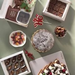 A look at my special Christmas menu. I offer a variety of gift boxes, including this spread with a Christmas tree cookie cake, classic plum cake, and boxes of fudge and brownies.